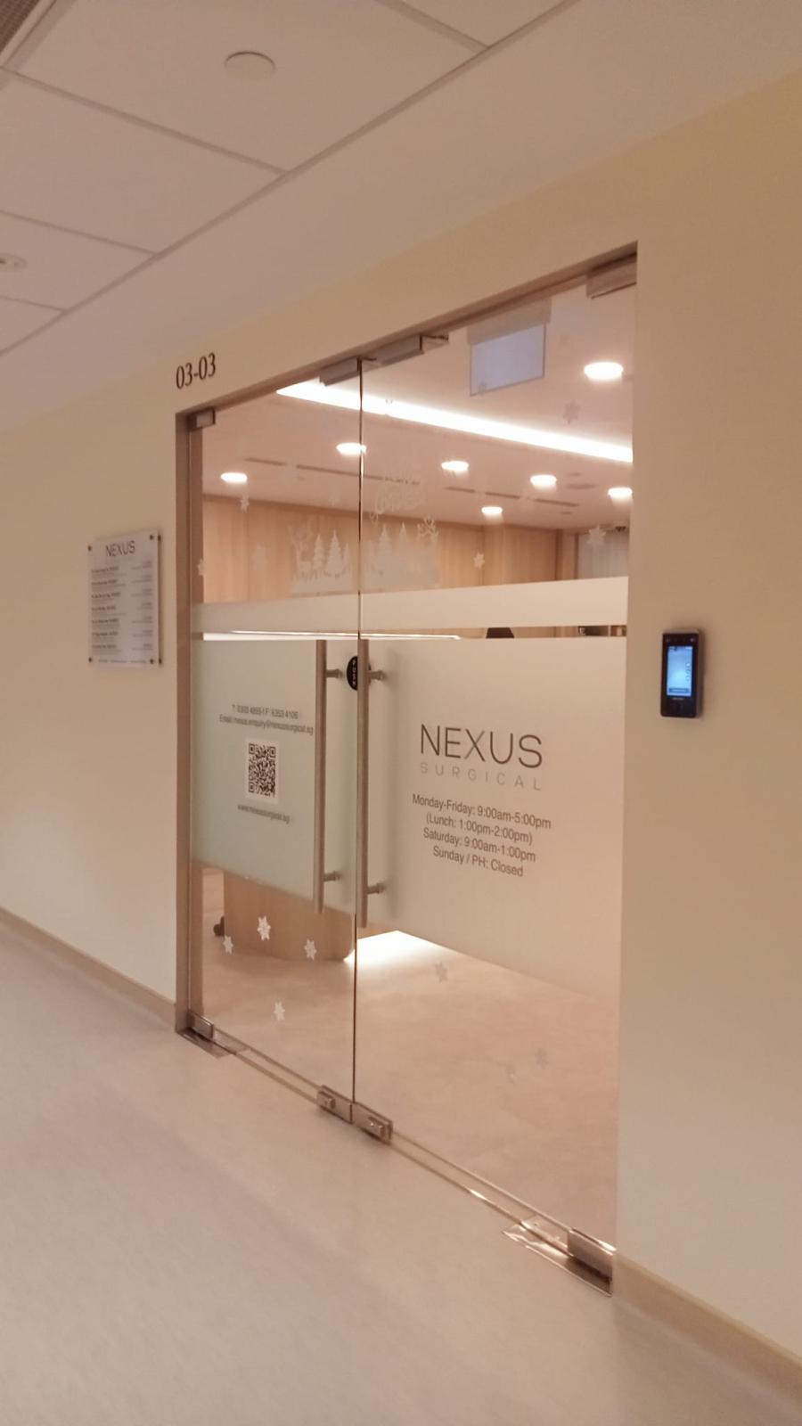 Glass double doors to Nexus Surgical clinic in a beige hallway; frosted doors with logos visible inside.